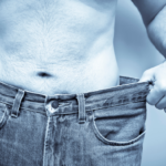 Man showing a slimmer waist after successful weight loss with a medically supervised weight loss program.