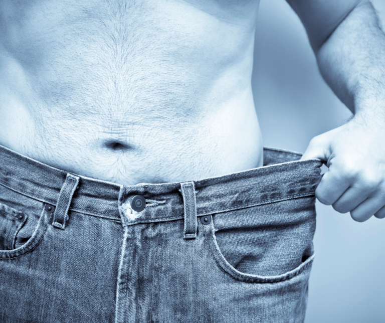 Man showing a slimmer waist after successful weight loss with a medically supervised weight loss program.