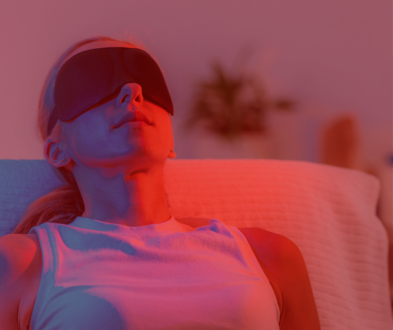 Woman using a red light therapy device at home as part of her wellness and recovery routine.