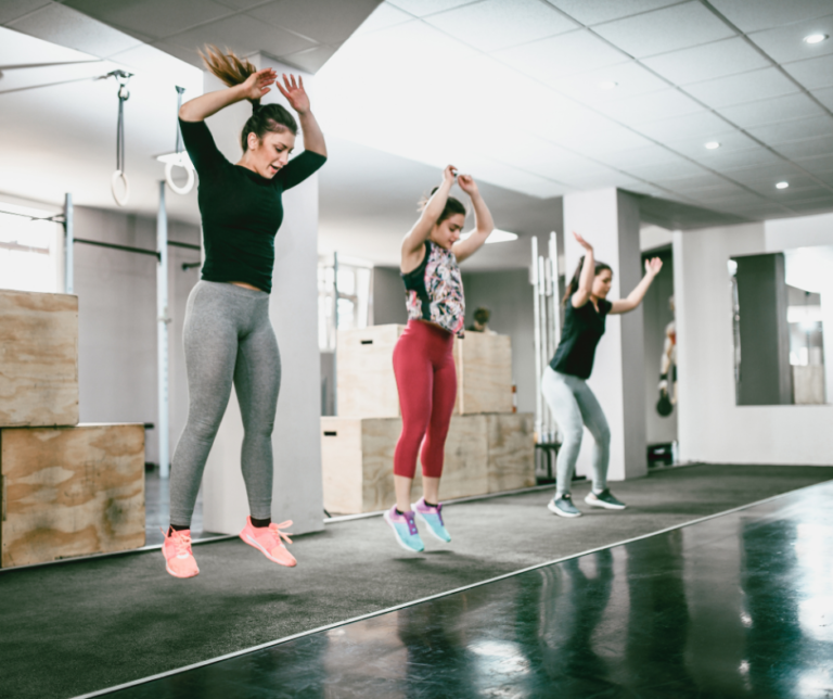 Women exercising and jumping at the gym, highlighting the importance of pelvic floor health and strength.